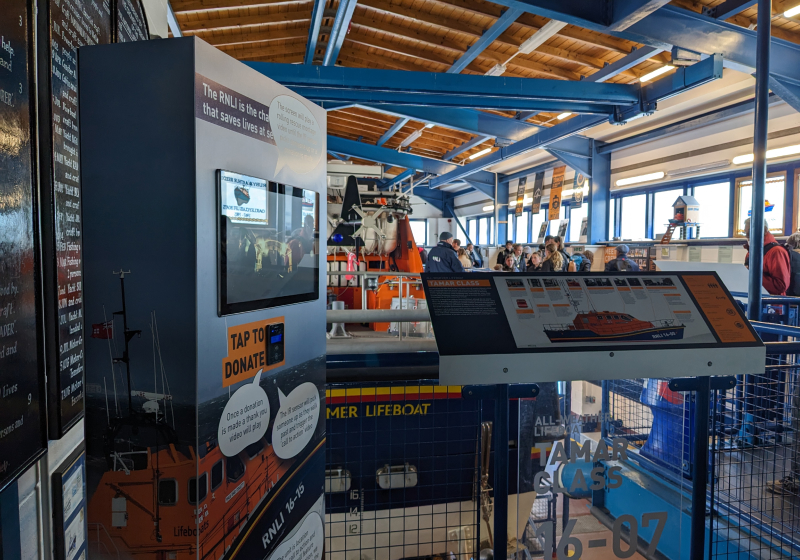 Photo of the Donation Triggered Video plinth with a video screen display and contactless payment reader.